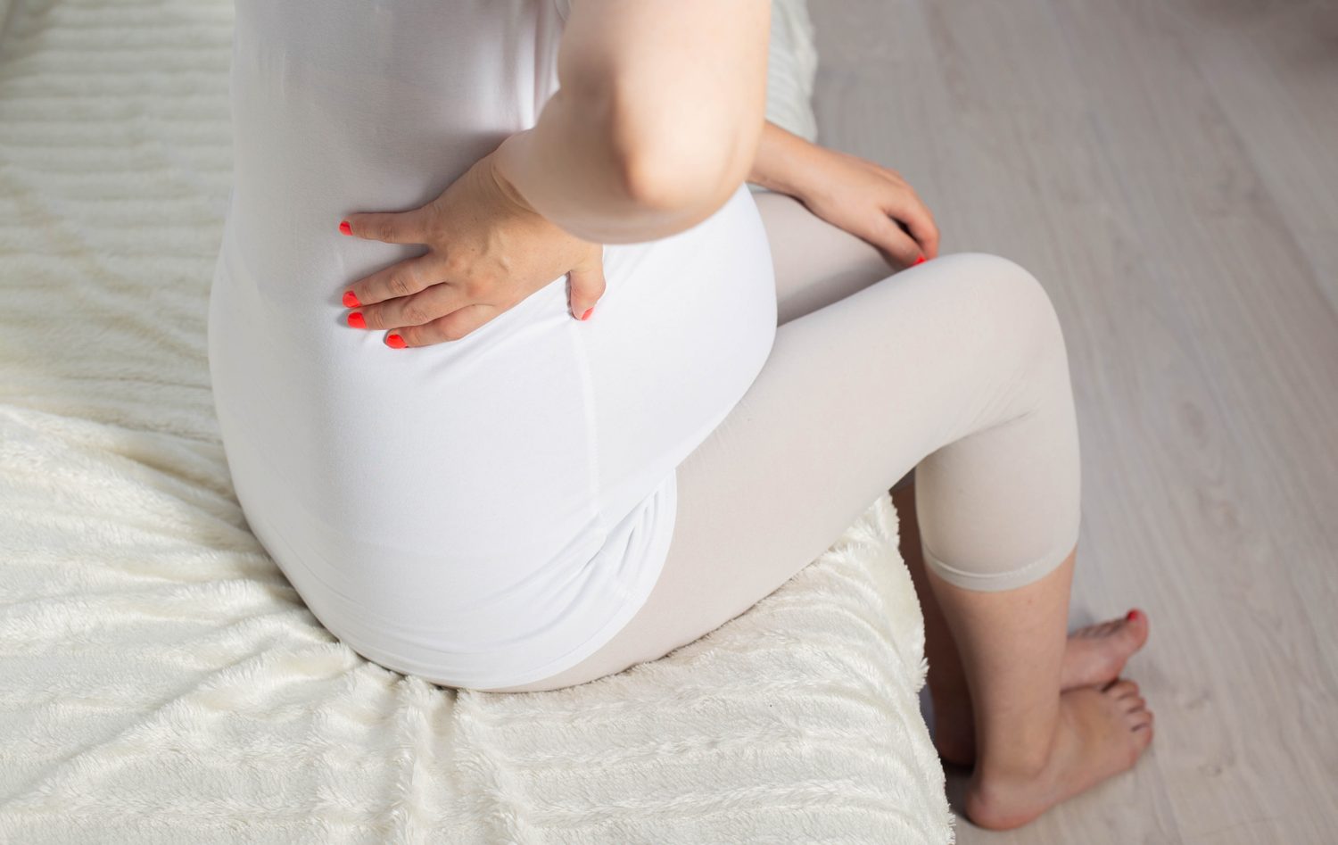 Femme enceinte soutenant son bas-ventre en raison d’une douleur au pubis.